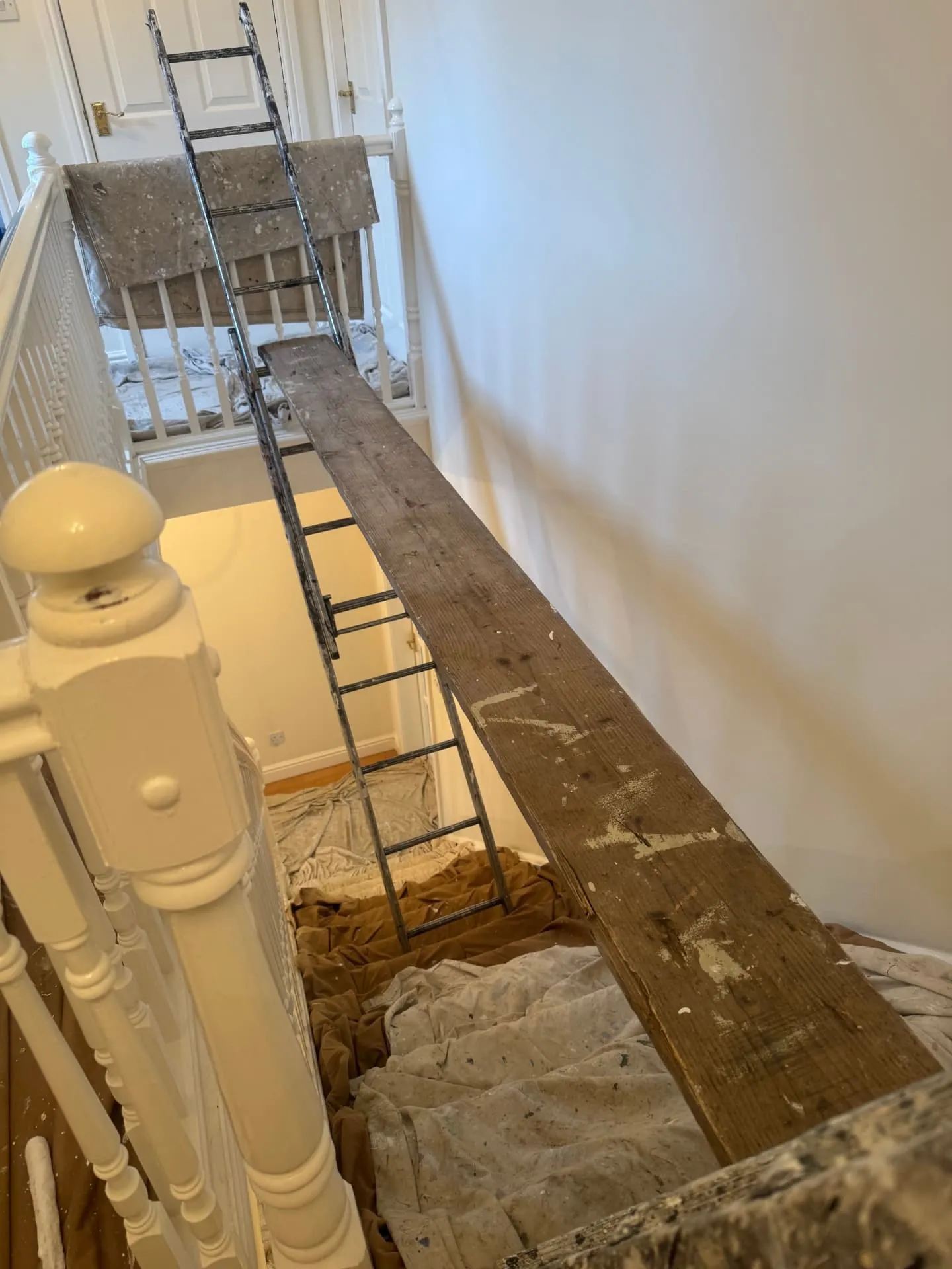 Staircase in Bonnyrigg boarded out with ladder and plank so W J Crighton can reach the stairwell walls safely