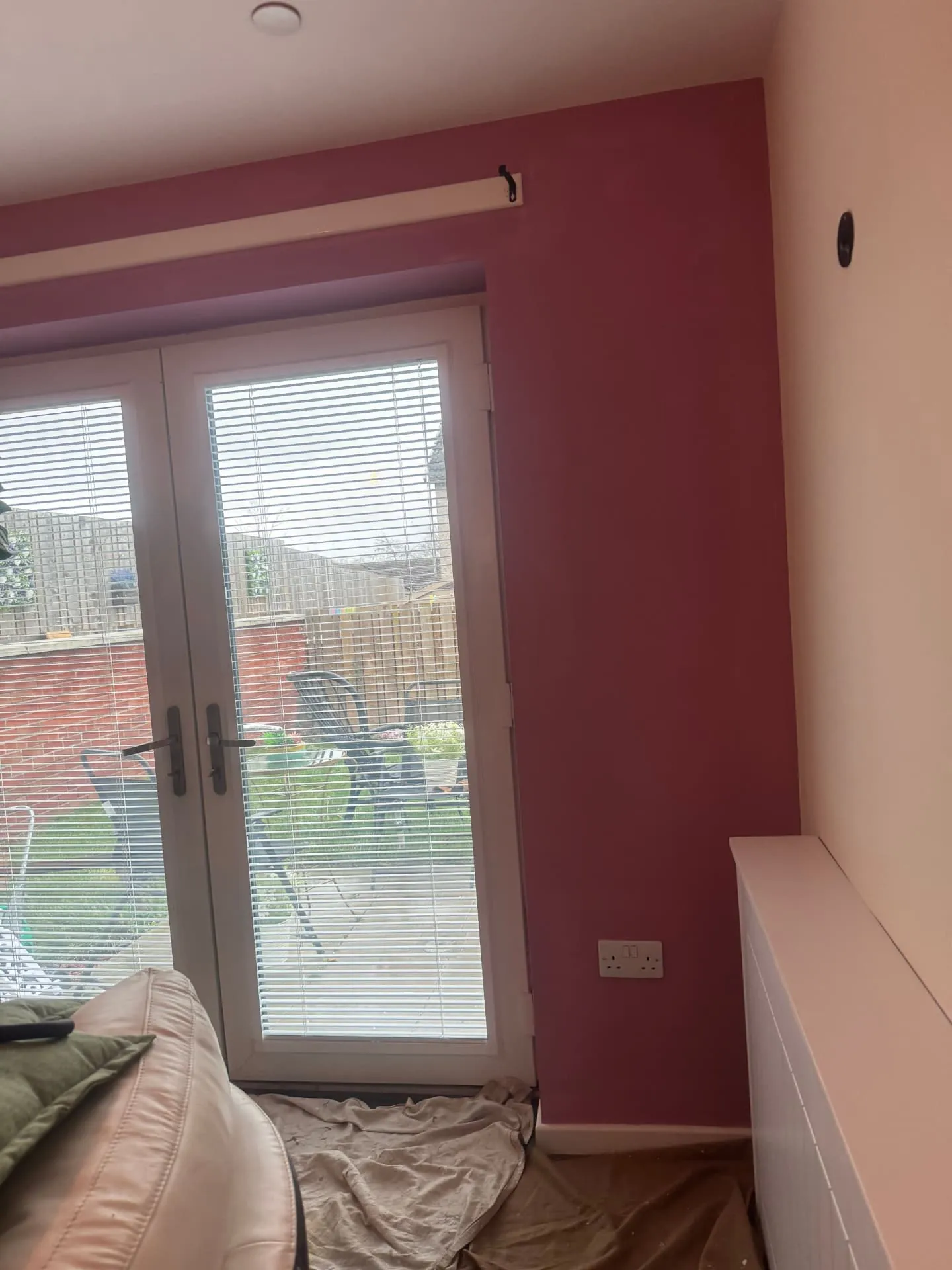 French doors in a Midlothian living room framed by a raspberry wall, cut in neatly against white frames