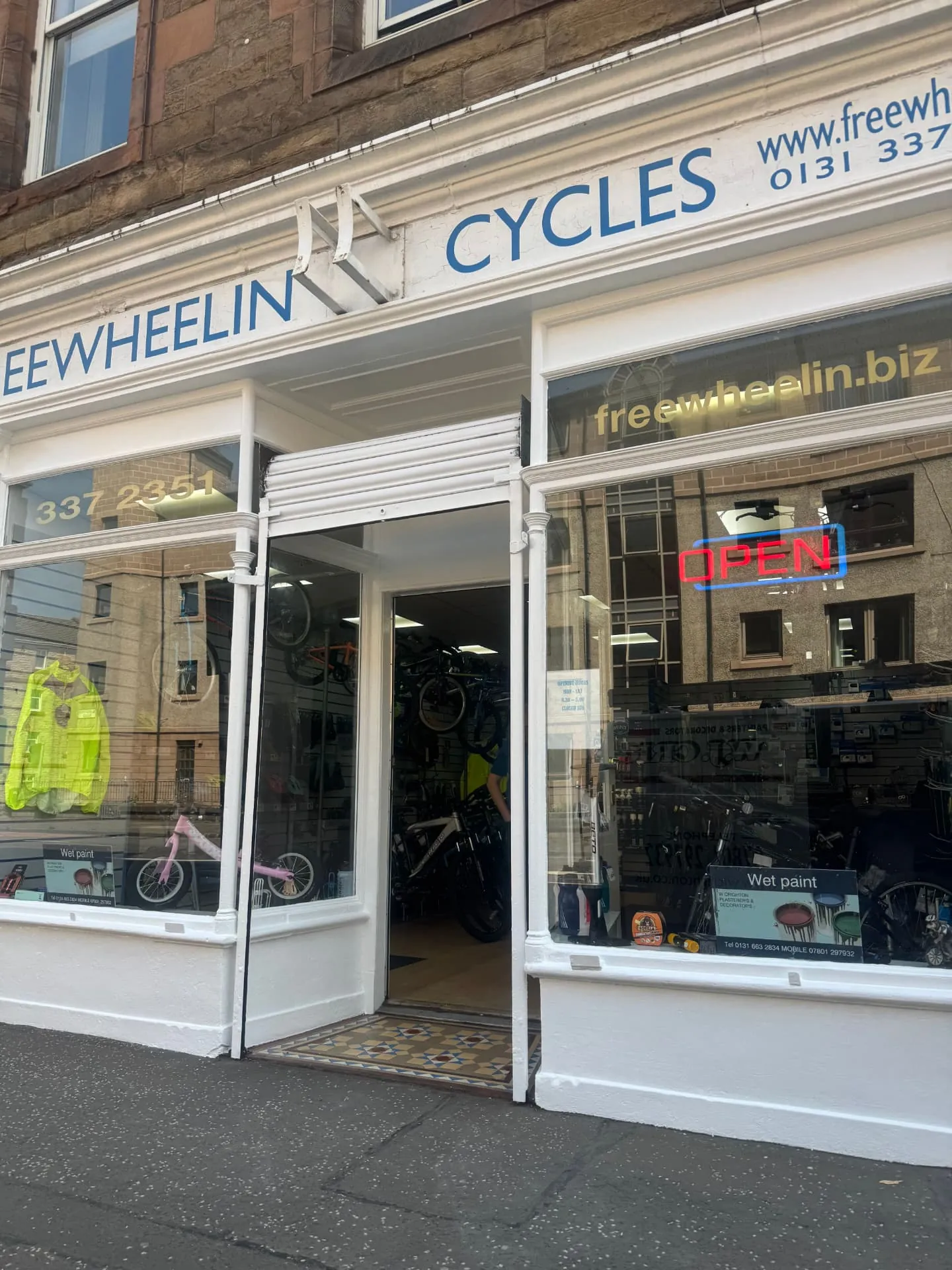 Freshly glossed white shopfront timbers in Edinburgh with a wet paint sign in the window