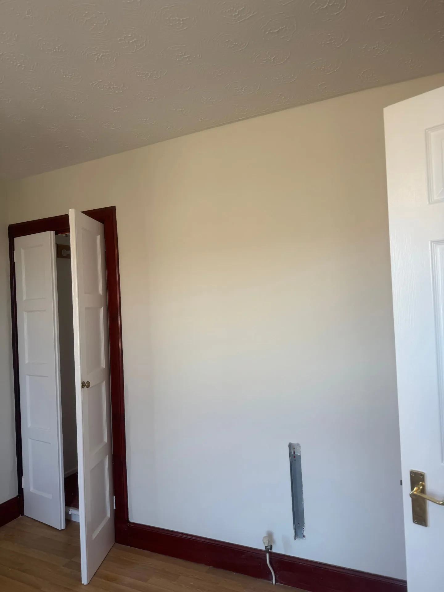 Cream painted wall with deep red gloss door frame and skirting in a Midlothian period house