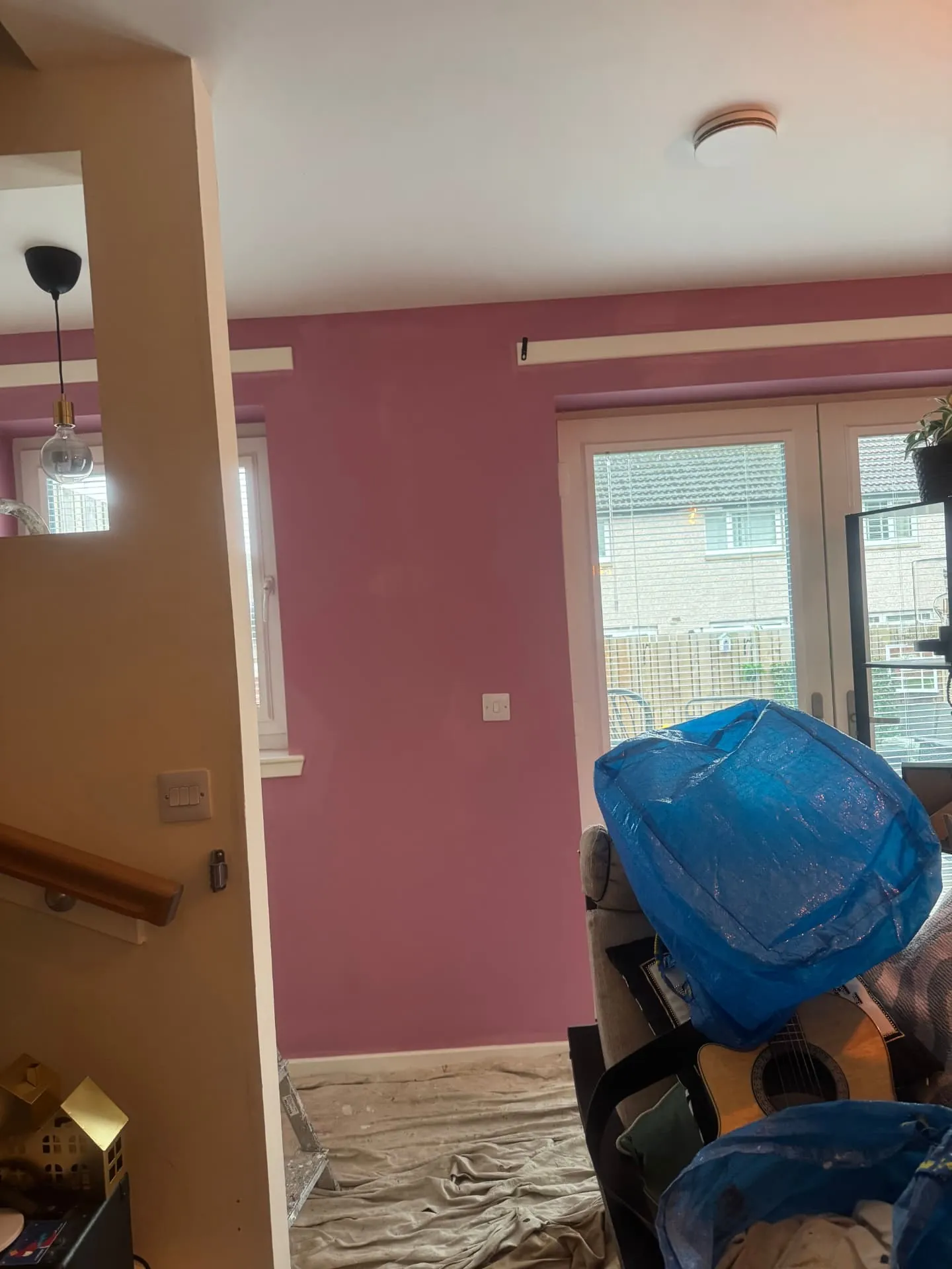Open-plan living space in Dalkeith with a dusky pink feature wall painted by W J Crighton