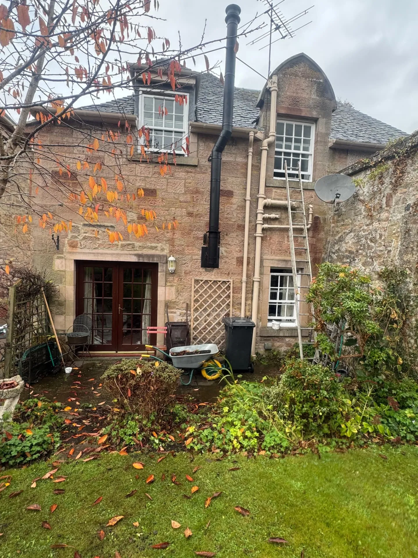 Freshly painted stone house exterior in Midlothian by W J Crighton, ladder up to white sash windows