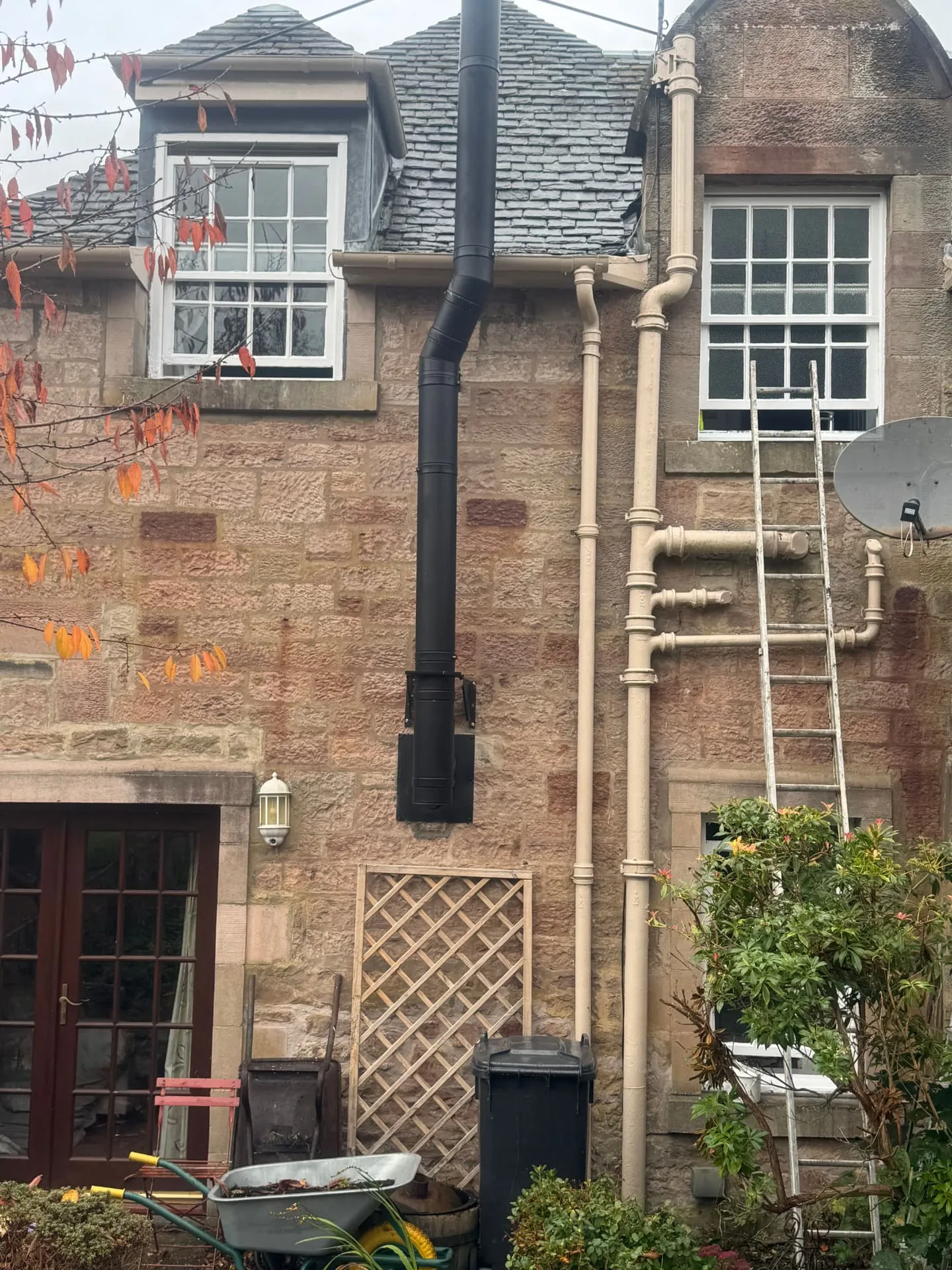 Rear elevation of a Midlothian stone house with cast iron downpipes and window frames repainted by hand