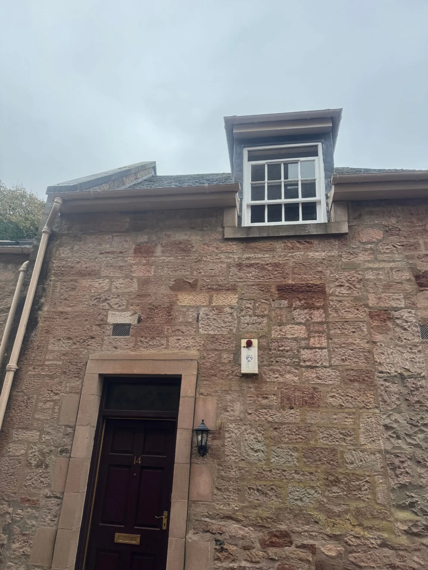 Traditional sandstone house near Penicuik with freshly painted white sash dormer and repainted gutters