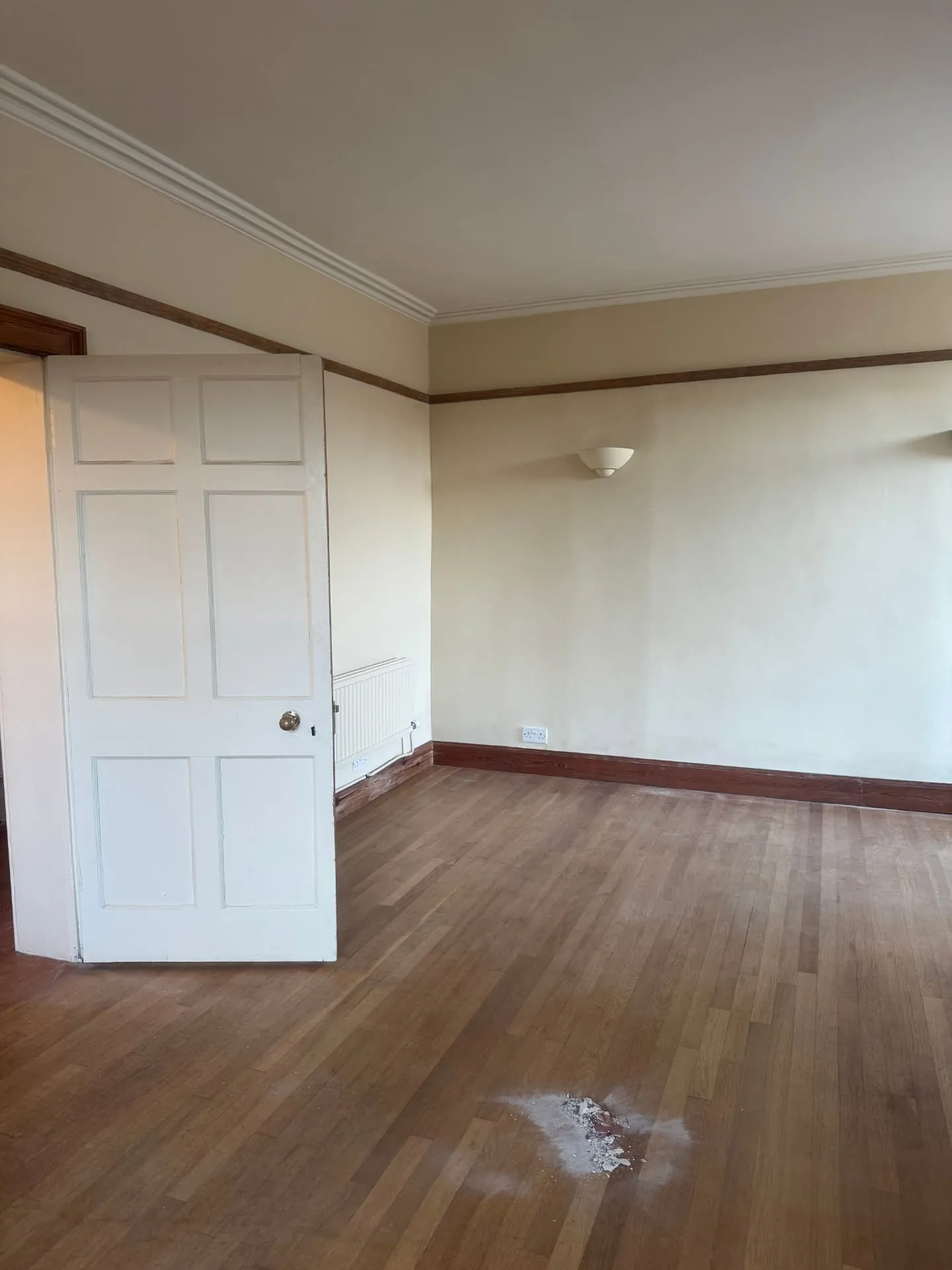 Large room in an Edinburgh property repainted in warm cream with white doors and timber picture rail